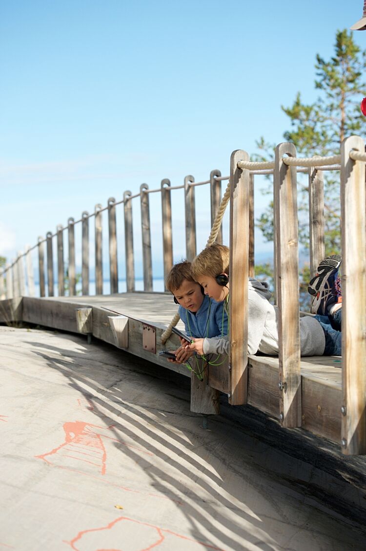 Bilde av barn som ser på bergkunst